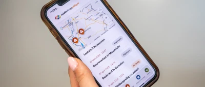 Een hand houdt een smartphone vast met een kaart en locaties aangegeven.