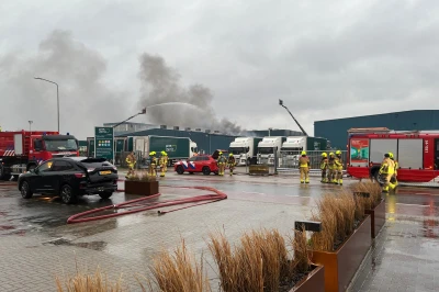 Brandweer is actief bij een pand met rookpluimen en meerdere voertuigen.
