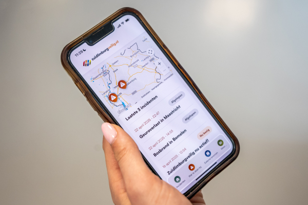 Een hand houdt een smartphone vast met een kaart en locaties aangegeven.