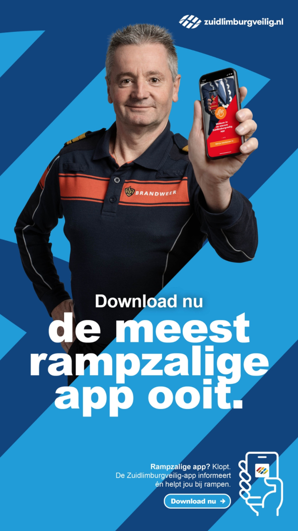 Een man in uniform houdt een smartphone omhoog, glimlachend, op een blauwe achtergrond.