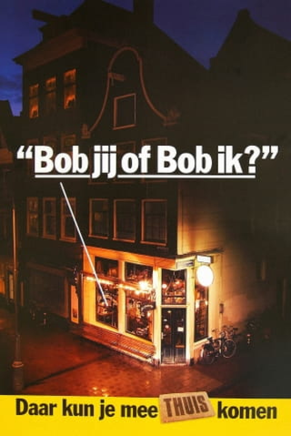 Een nachtelijke straat met een verlicht café en een tekstballon met de woorden 'Bob jij of bob ik?'